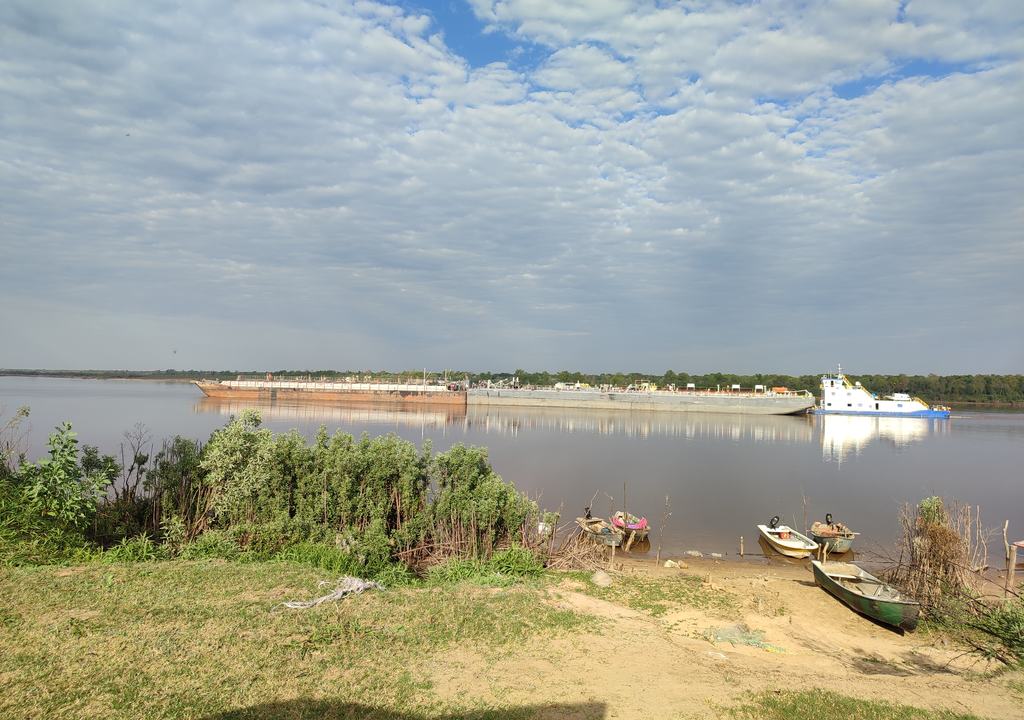 Convoy de barcazas pasando frente a la costa del río Paraguay en Ñeembucú